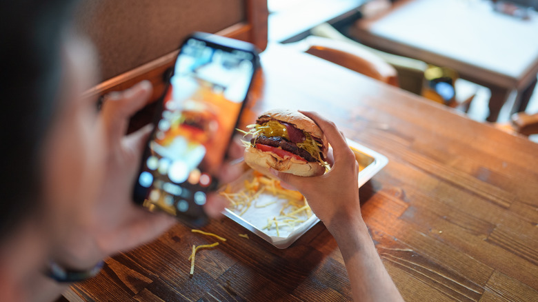 Someone photographing their own hamburger