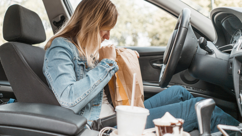 Someone looking at their fast food in a car