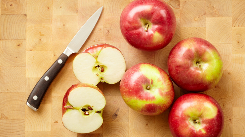Apples on wooden surface with knife