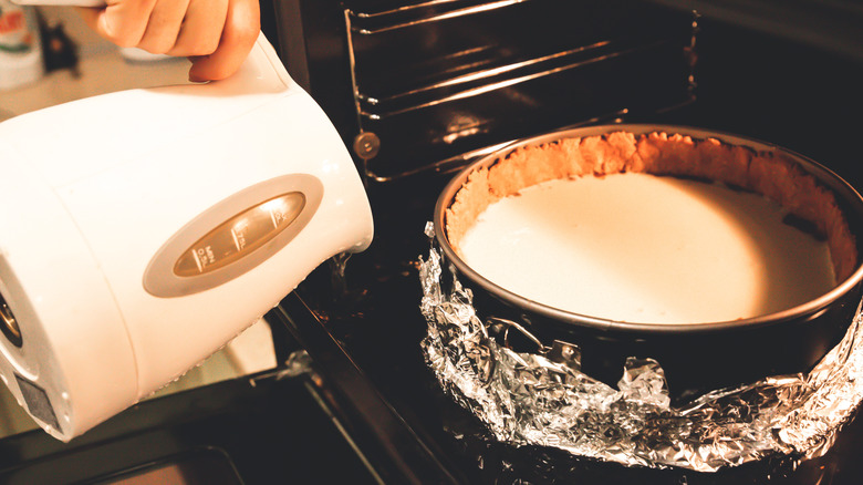 Electric kettle pouring water to cheesecake