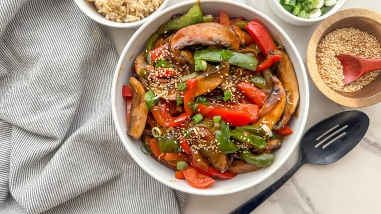 Vegan pepper portobello steak and rice in a bowl garnished with sesame seeds
