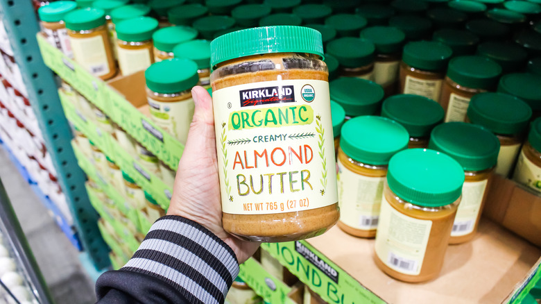 Hand holding Kirkland organic almond butter