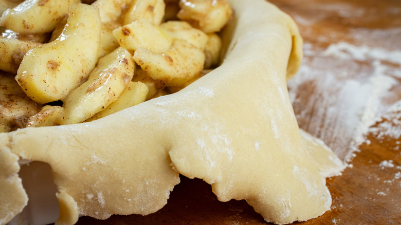 Pie filling with apples and draped pie dough