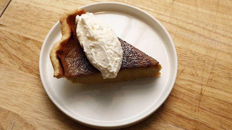 A slice of pumpkin pie with whipped cream