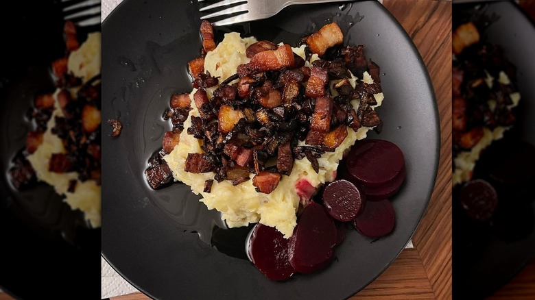 Mashed potatoes topped with bacon on blue plate