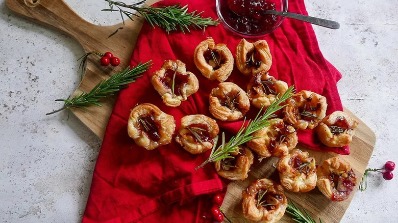 cranberry and rosemary on wooden board and red tablecloth