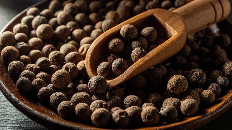 Whole allspice in wooden bowl