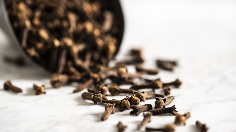 Cloves spilling out of black bowl 