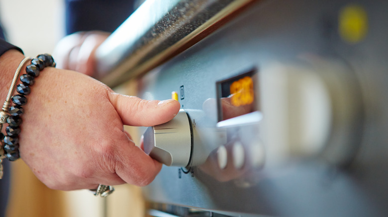 Person rotating oven dial