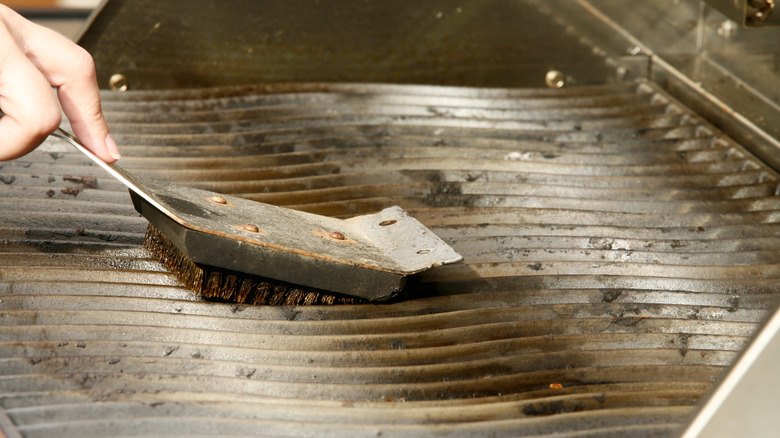 Person cleaning off grill