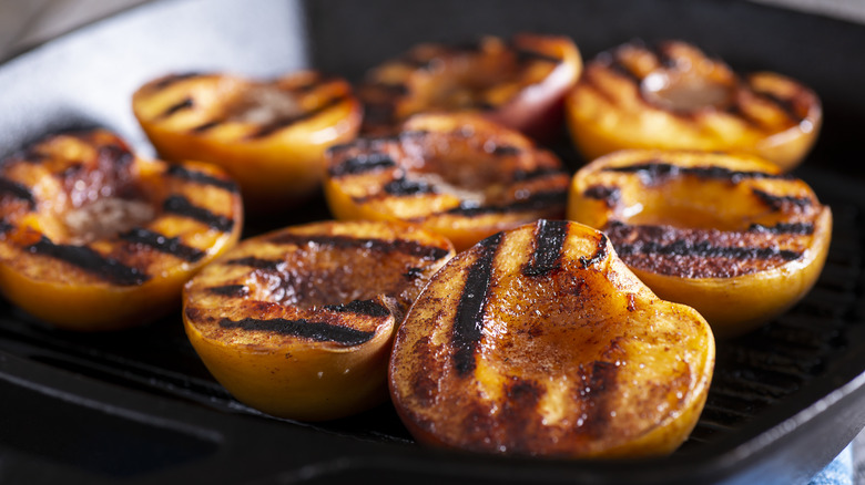 Grilled peach halves in pan