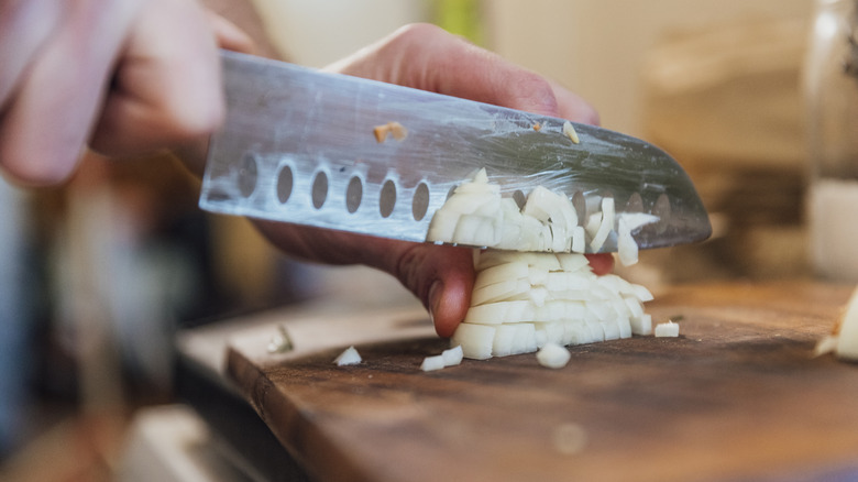 Person chopping onions with knife