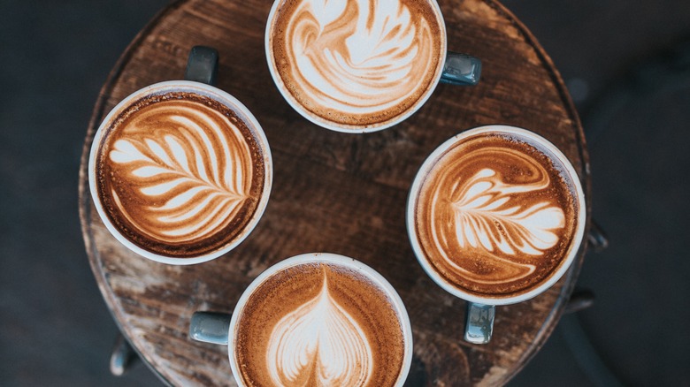 Four lattes with foam art