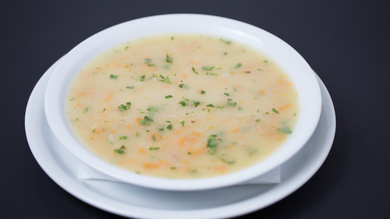 Bowl of cream of chicken soup on black background