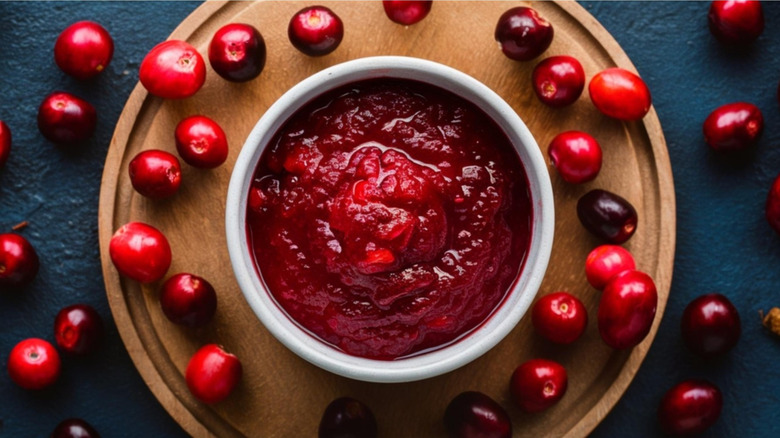 Cranberry sauce with cranberries on a wooden surface