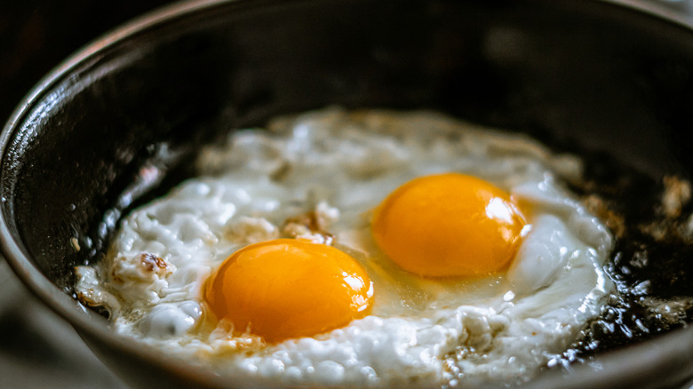 Frying two eggs in a pan with oil