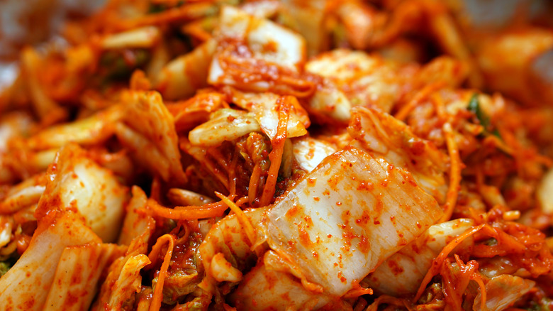 Red kimchi in a bowl with chile flakes