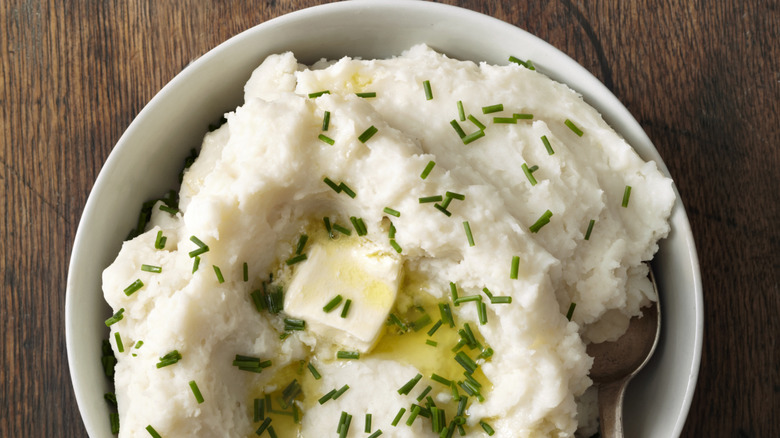 Mashed potatoes with piece of butter and herbs