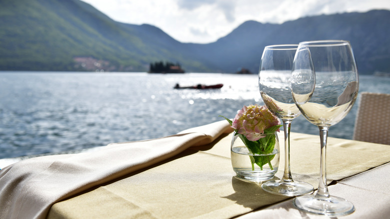 glasses of wine near lake 