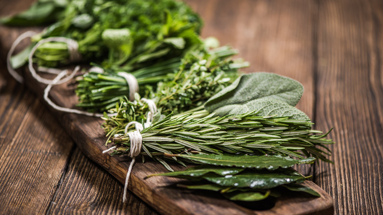 Aromatic herbs on wooden board