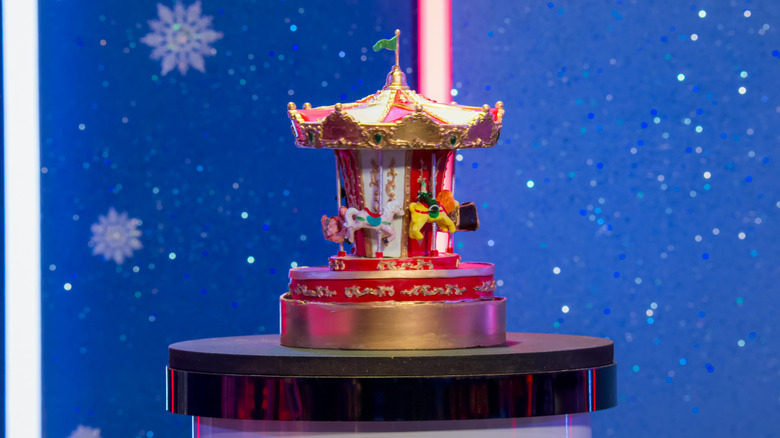 Carousel toy cake against a sparkly blue background