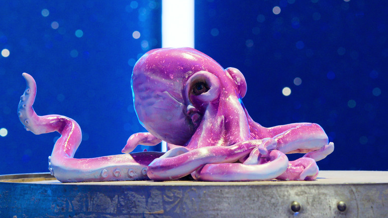 Octopus cake on a table against a sparkly blue background