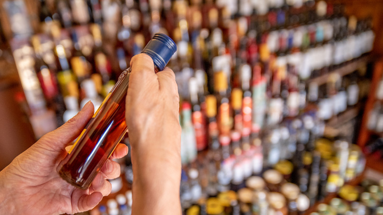 brown liquor bottle selected at store