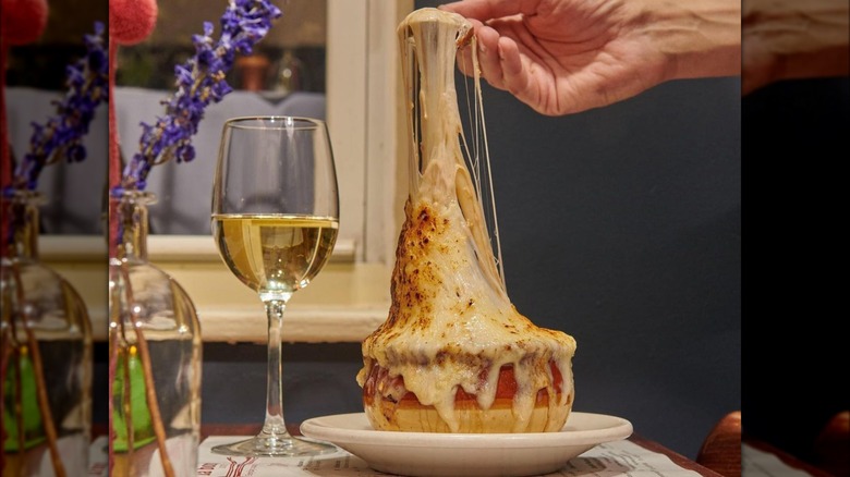 hand stretching cheese from bowl