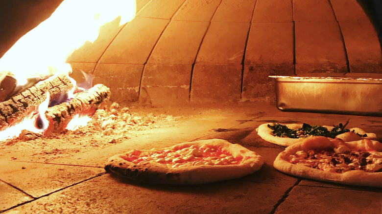 Pizza cooking in wood oven