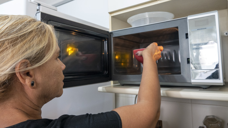 Person putting bowl in microwave