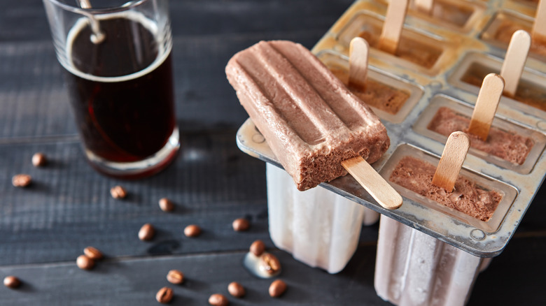 Brown popsicle resting on mold 