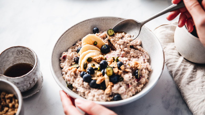 Hand stirring oatmeal in bowl