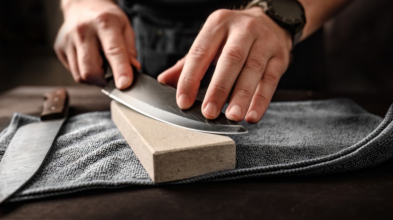 sharpening knife on whetstone