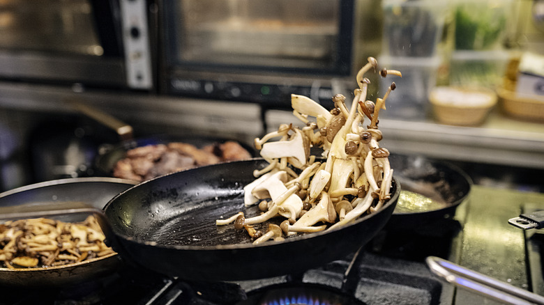 tossing mushrooms in pan