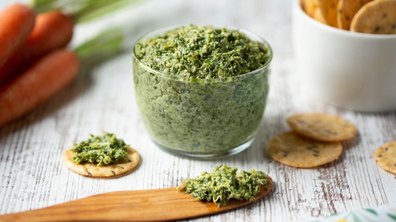 Green pesto in bowl with crackers