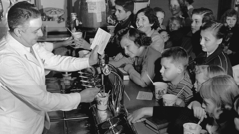 Children drinking soda at pharmacy