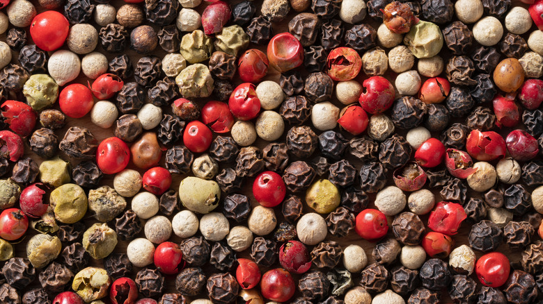 Multicolored peppercorns on wood