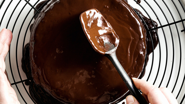 Putting chocolate ganache on a cake 