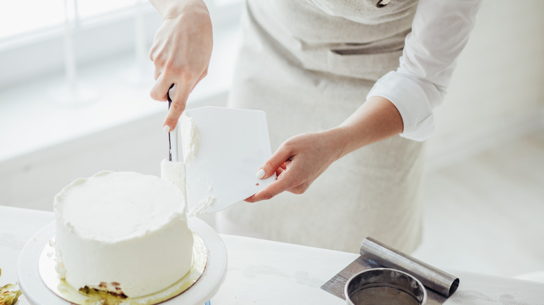 Person decorating a cake