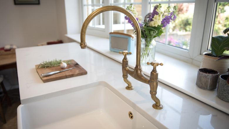 Brass faucet over white kitchen sink