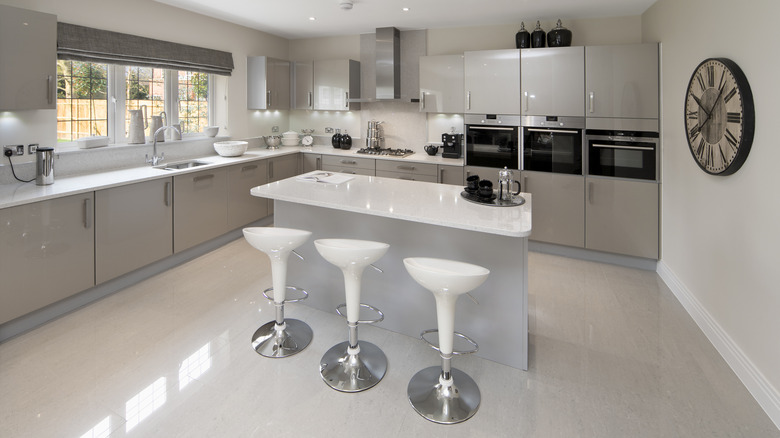 All-white kitchen with stainless steel appliances and high-gloss floors