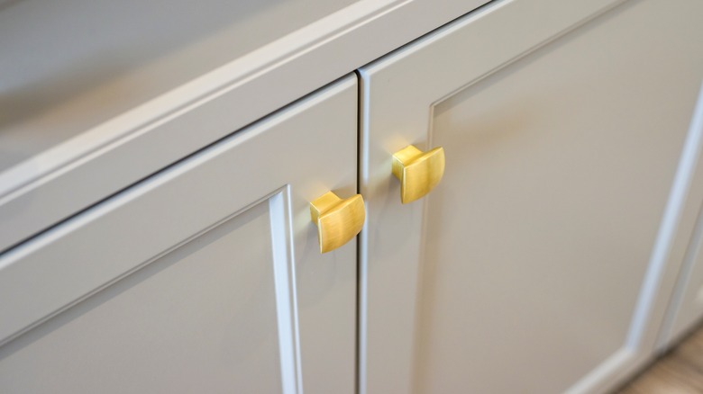 White kitchen cabinet doors with two gold knobs