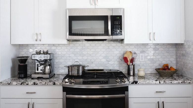 All-white kitchen with stainless steel over-the-range microwave