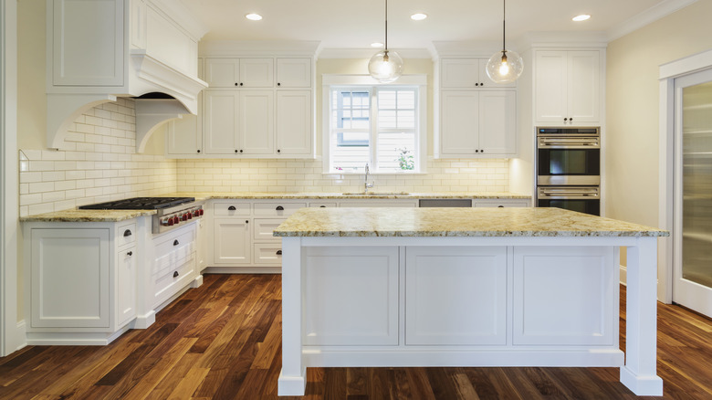 White kitchen with island and granite countertops