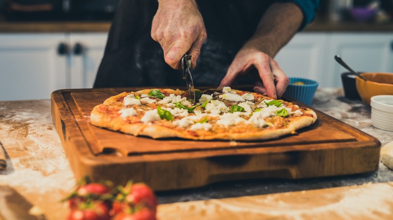 Man slicing pizza