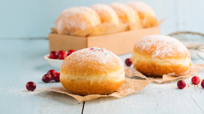 two sugar dusted sufganiyot on paper