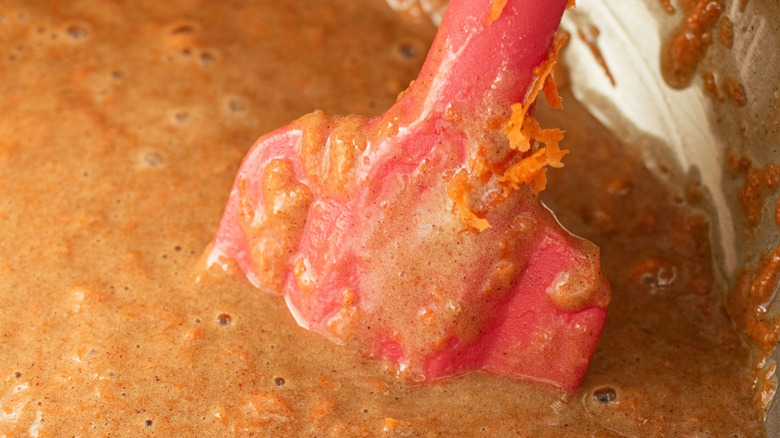 Red spatula in carrot cake batter