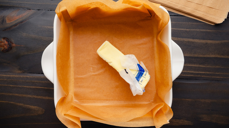 Square pan with parchment paper and butter