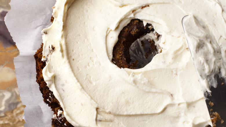 Icing on homemade carrot cake with knife