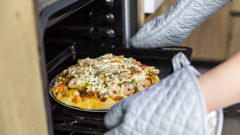 Person baking pizza home oven